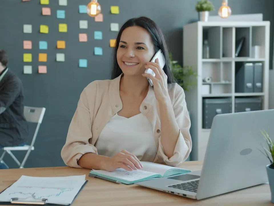A woman talking on the phone at her desk