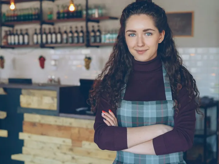 A café owner standing behind her counter